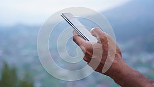 Person using mobile phone. Closeup of businessman holding phone in hand, checking news or messages on a vacation.