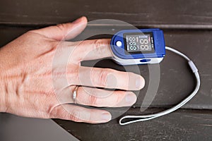Person using oximeter for monitoring peripheral oxygen saturation, close up view
