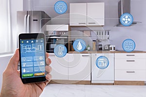 Person Using Smart Home Application On Smartphone