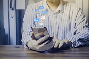 Person using a social media marketing concept on mobile phone with notification icons of like, message, comment and star above