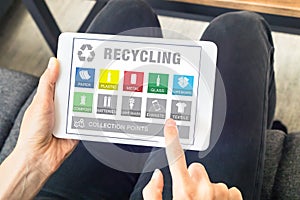 Person using tablet website for sorting recyclable waste material, recycling photo