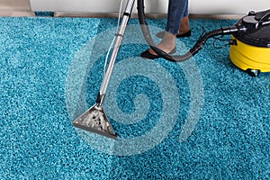 Person Using Vacuum Cleaner For Cleaning Carpet