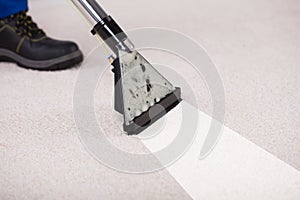 Person Using Vacuum Cleaner For Cleaning Carpet