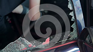 Person is vacuuming broken window from inside of a car