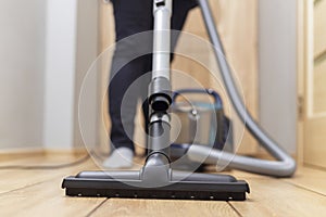 Person vacuuming floor. Household chore and cleaning concept.