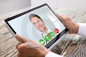 Person Videochatting With Doctor On Digital Tablet