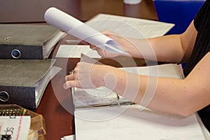 A person viewing the documents on the table in the living room, you can see hands and documents.