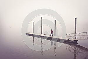 Person Walking on Dock in Fog