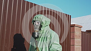 person walking near fence in protective equipment during pandemic