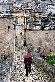 A person walking through the rain on a path in downton Matera, Italy