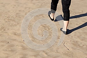 Person walking on sandy surface laving footprints behind