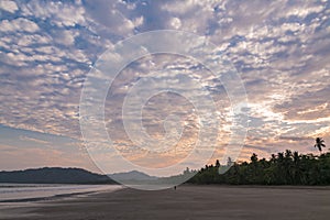 Person walking in a sunset at Tambor beach, Puntarenas Costa Rica photo