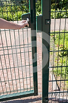 Person wants get in on playground through the little gate of welded wire