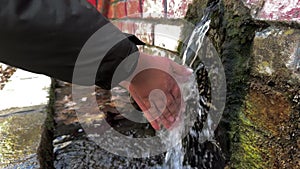 Person washing hands in forest water spring 2 slow motion
