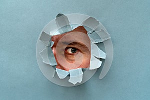 The person watching through a hole in a grey paper