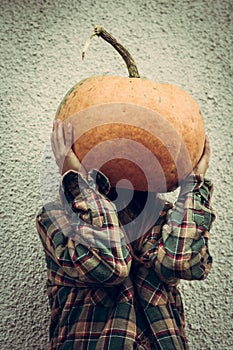 Person wear pumpkin on head.