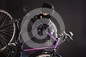 Person Wearing Balaclava Stealing A Bicycle photo