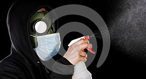 Person wearing hazmat style gas mask and medical mask cleaning with spray bottle