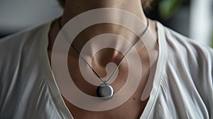 A person wearing a necklace with a pendant that houses a tiny discreet stimulation device photo