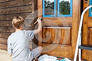 Person working on applying wooden door with protective urethane coating
