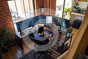 A person working at a desk with multiple monitors in a modern workspace