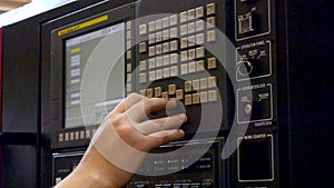 Person works behind the control panel of the production machine at the factory