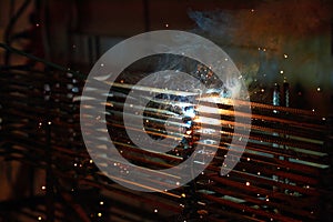 A person works with welding, sparks, close up, construction photo