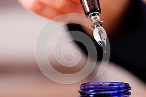 Person writing a letter with pen and ink