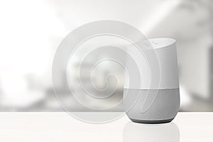 Personal assistant loudspeaker on a white wooden shelf of a smart home living room. Next, a book. Empty copy space photo