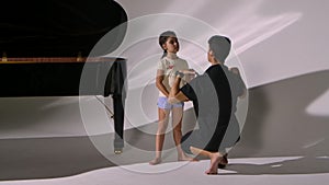 Personal ballet lesson for little girl. Professional teacher teaches dance elements to ballerina. Choreographer corrects