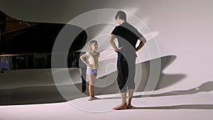 Personal ballet lesson for little girl. Professional teacher teaches dance elements to ballerina. Individual practice of