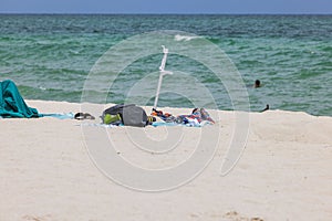 Personal belongings scattered carelessly on a sandy beach. Miami Beach.