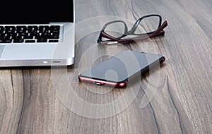 Personal computer, glasses and cellphone on an office or study table