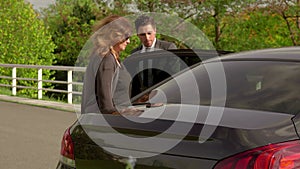 Personal driver waiting for his rich women client to get into the car