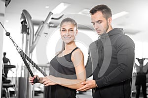 Personal fitness trainer with his client in gym.