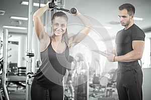 Personal fitness trainer with his client in gym.