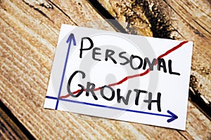 Personal growth - handwriting in a black ink on wooden background concept for personal development photo