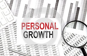 PERSONAL GROWTH text on paper with calculator,magnifier ,pen on graph background