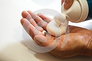 Personal hygiene with hands pouring depilatory foam on the hand