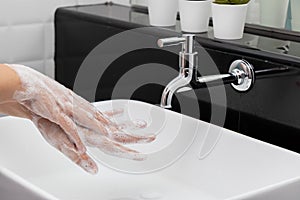 Personal hygiene. washing hands, rubbing hand thoroughly with soap that has a lot of bubbles for cleaning and disinfection photo