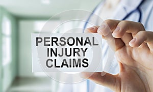 Personal Injury Claims text card in Hand, concept background