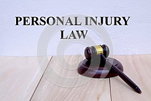 Personal Injury Law written on the wall with gavel on wooden background. Law concept