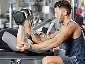 Personal instructor helping a man in the gym