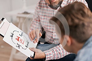 Personal life coach explaining graph to his young patient