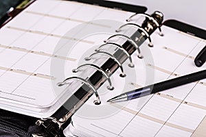 Personal organizer or planner with pen on white background