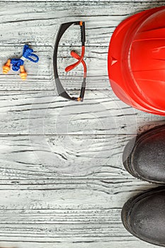 Personal protective equipment: black gloves goggles glasses on a wooden background