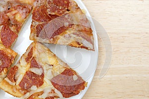 Personal size pepperoni pizza slices on a white plate