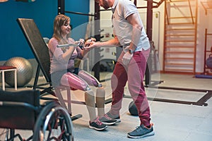 Personal trainer assisting woman with disabilities in her workout