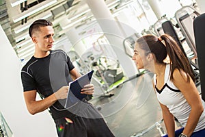 Personal trainer explaining exercise results to his female client in a gym