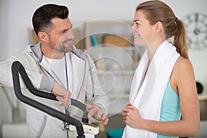 personal trainer explaining settings on exercise machine